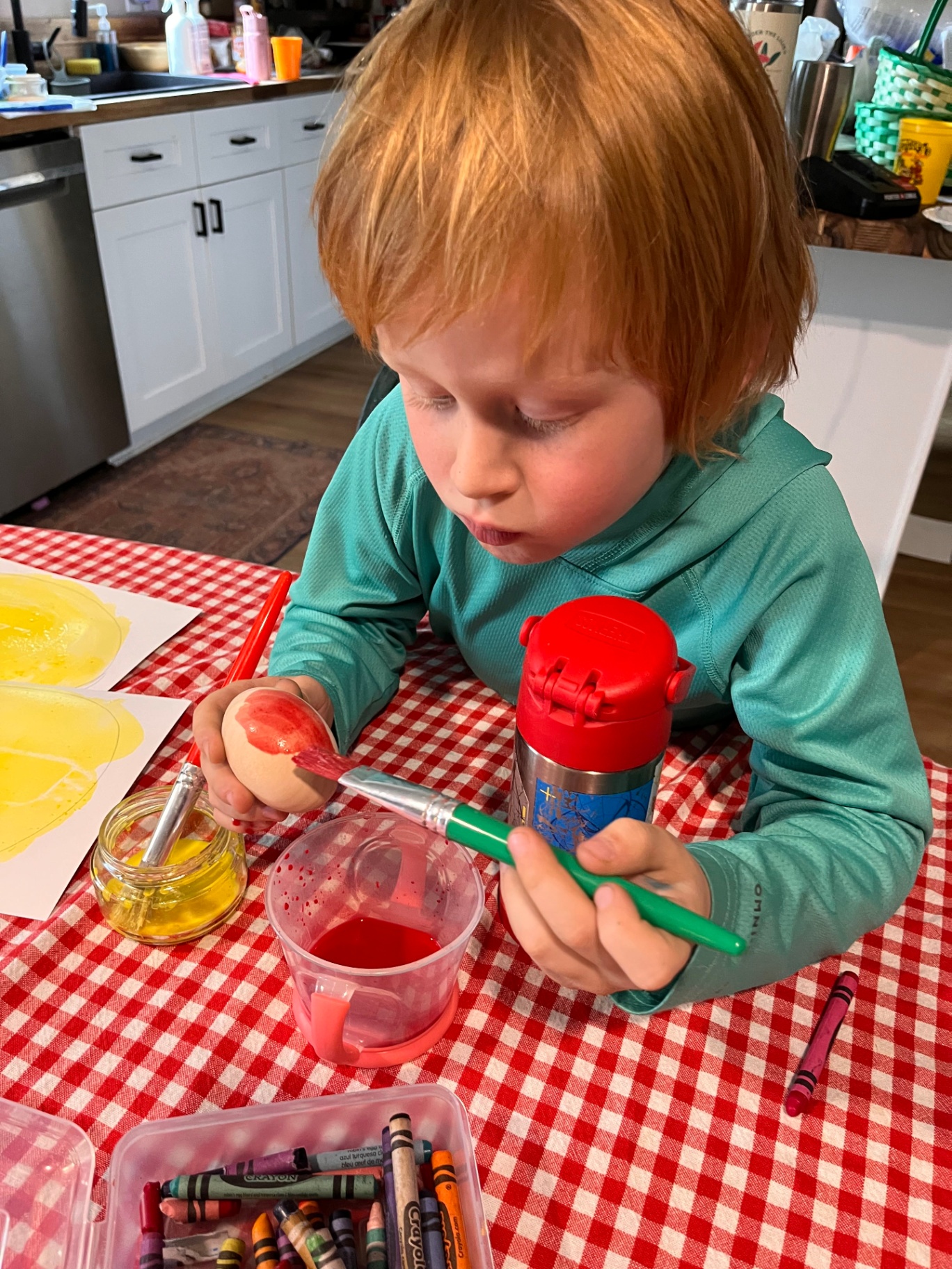 A child carefully painting an egg
